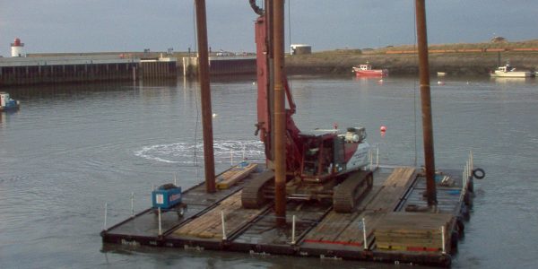 Piling rig mounted on Uniflote pontoons carrying out marine foundation work in a harbour