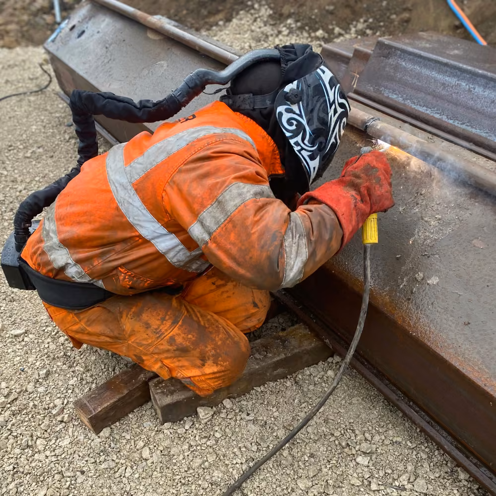 Welder joins a clutch bar to a steel sheet pile to form an interlocking connection.